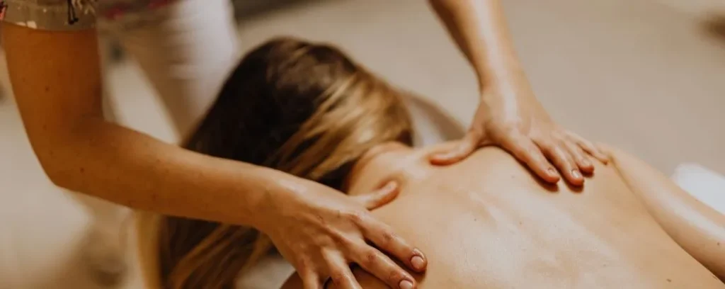 Terapeuta realizando masaje en la espalda para aliviar contracturas y relajar la musculatura